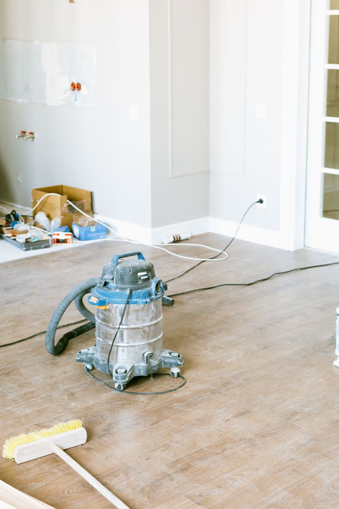 home-services-01 Vacuum and tools in a room undergoing renovation, showcasing home improvement.